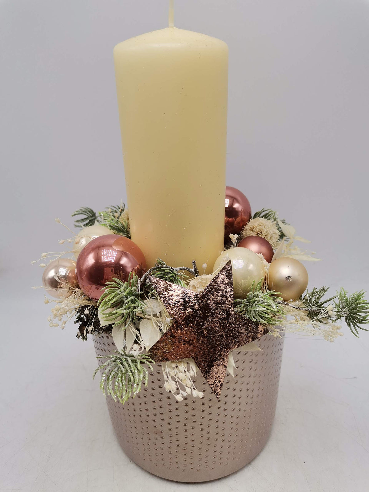 Adventsgesteck von vorn: Kerze, Kugeln in Rosé und Creme, beschneite Zweige und Glitzerstern