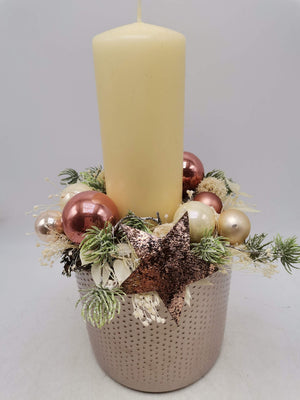 Adventsgesteck von vorn: Kerze, Kugeln in Rosé und Creme, beschneite Zweige und Glitzerstern