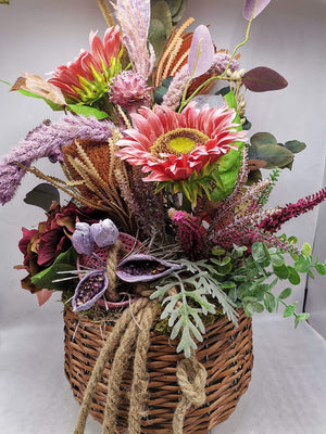 Detail des Herbstgestecks: rosa Sonnenblume mit gelber Mitte, weinrote Hortensie und Naturkordel am Korb