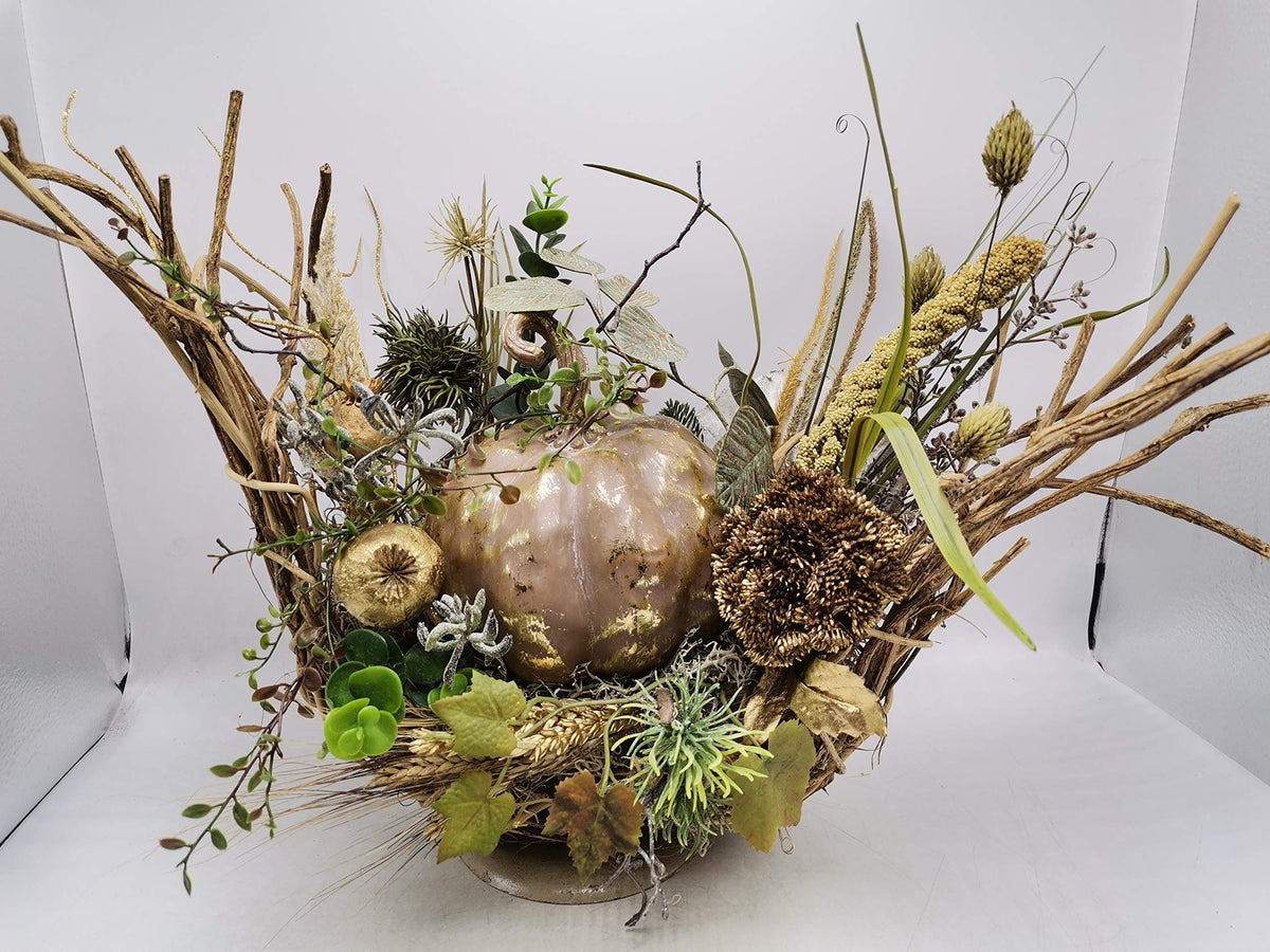 Herbstgesteck mit goldbraunem Kürbis, Mohnkapsel, Ähren und Gräsern in einem breiten Kranz aus Geäst